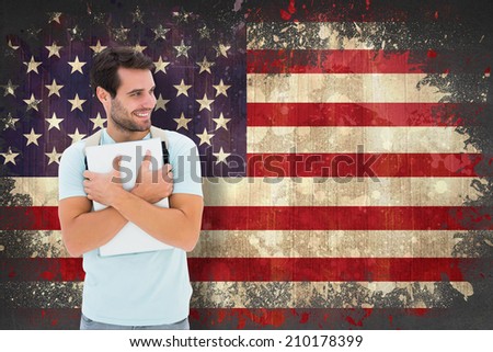 Student holding laptop against usa flag in grunge effect