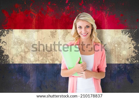 Young pretty student smiling against netherlands flag in grunge effect