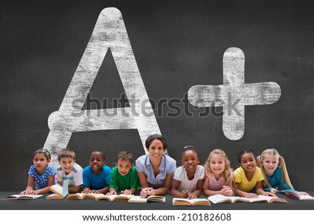 Cute pupils smiling at camera with teacher against black wall with a plus grade