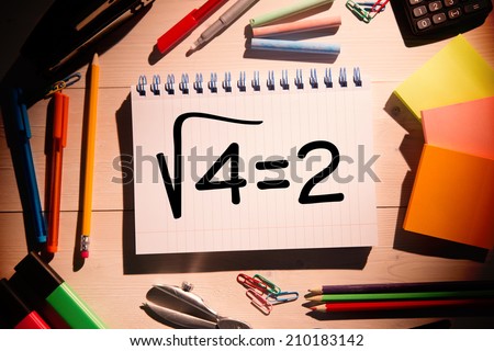 Square root of four on notepad against students desk