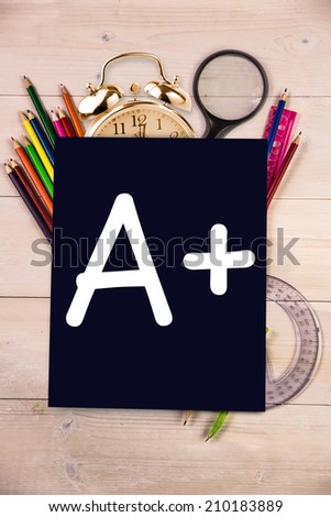 A plus grade against students desk with black page