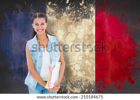 Student holding notepads against france flag in grunge effect