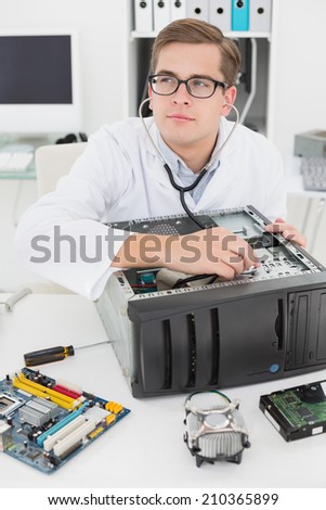 Computer engineer listening to console with stethoscope in his office