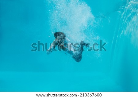 Full length portrait of a young man swimming underwater