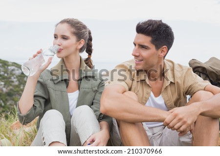 Young couple taking a break after hiking uphill