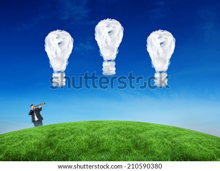 Composite image of businessman looking through telescope against cloud light bulbs