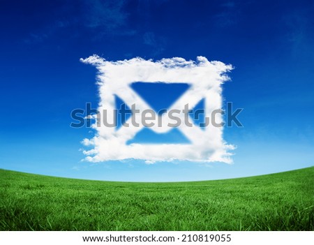 Cloud email against green field under blue sky