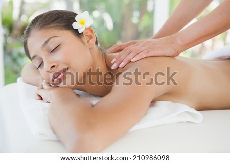 Beautiful brunette enjoying a back massage at the health spa