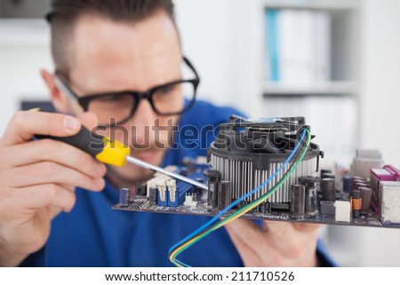 Computer engineer working on cpu with screwdriver in his office
