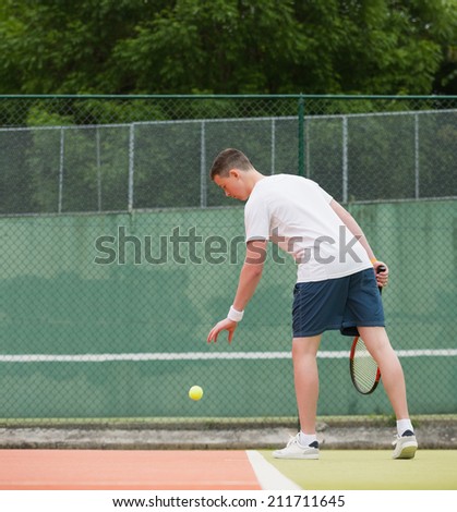 Young tennis player about to serve on a sunny day