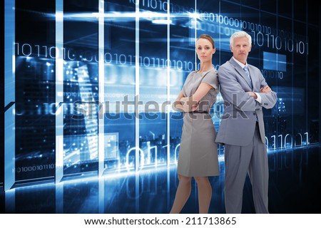 Serious businessman standing back-to-back with a woman against hologram interface in office overlooking city
