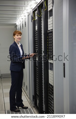 Technician working on servers using tablet pc in large data center
