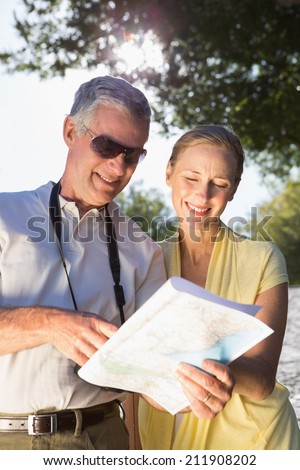 Happy senior couple using the map on a sunny day