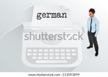 The word german and happy businessman standing with hands in pockets against typewriter