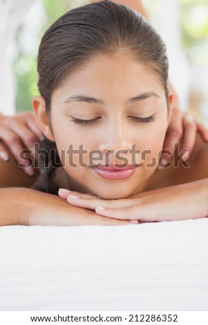 Beautiful brunette enjoying a massage at the health spa