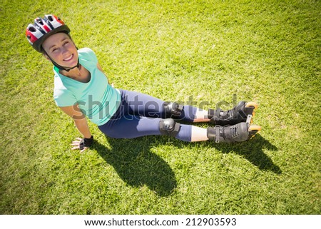 Fit mature woman in roller blades on the grass on a sunny day