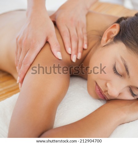 Beautiful brunette enjoying a shoulder massage at the health spa