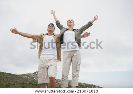 Low angle view of hiking young couple stretching hands on mountain terrain