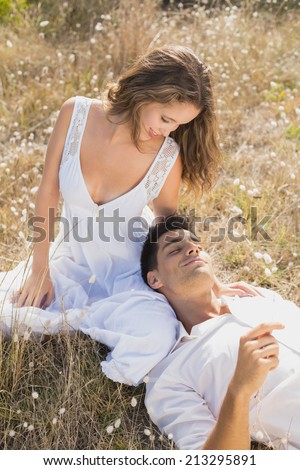 Relaxed young couple sitting on countryside landscape