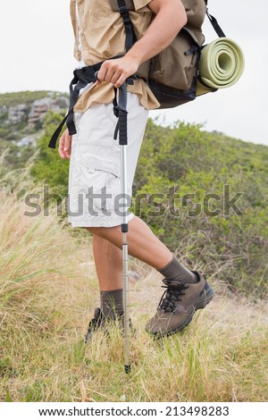 Side view low section of a hiking man walking on mountain terrain
