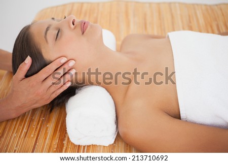 Beautiful brunette enjoying a head massage at the health spa