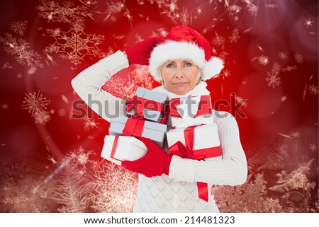 Festive woman holding gifts against red snow flake pattern design