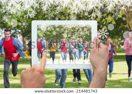 Hand holding tablet pc against college students running in the park