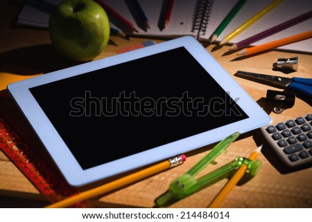 Students table with school supplies and tablet pc