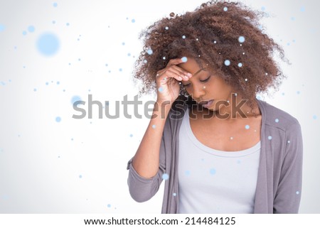 Sad woman holding her forehead with her hand against snow falling
