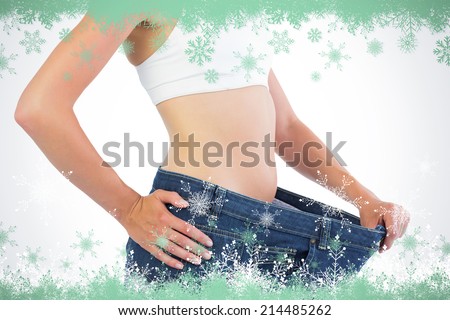 Close up of confident slim blonde wearing too big trousers against snow flake frame in green