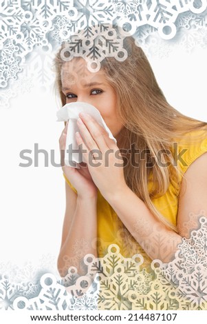 Portrait of a blond woman blowing against snowflakes on silver