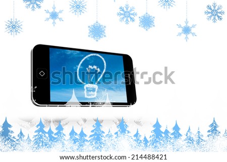 Snowflakes and fir trees against cloud light bulb on smartphone screen