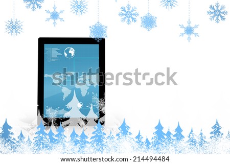 Snowflakes and fir trees against map on tablet screen