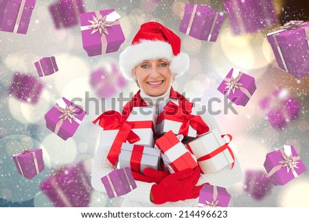 Festive woman holding gifts against light glowing dots design pattern