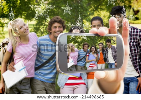 Hand holding smartphone showing group portrait of happy college friends