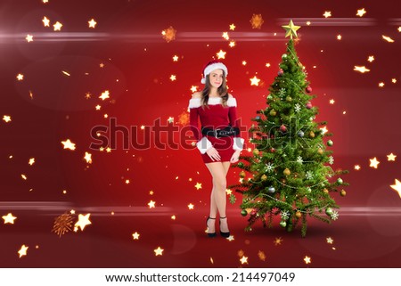 Sexy santa girl smiling at camera against bright star pattern on red