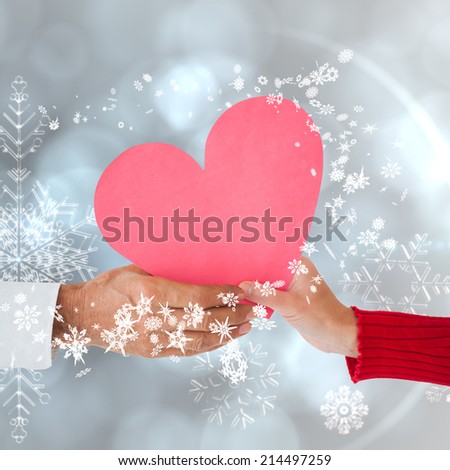 Couple holding heart against silver snow flake pattern design