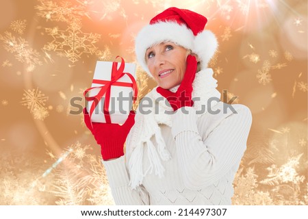 Festive woman holding gift against cream snow flake pattern design