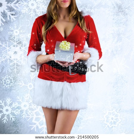 Sexy santa girl holding gift against silver snow flake pattern design