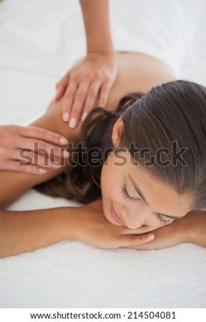 Beautiful brunette enjoying a massage at the health spa