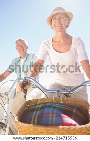 Happy senior couple going for a bike ride on a sunny day