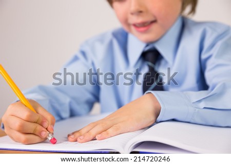 Student writing notes in notepad on white background