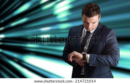 Handsome businessman checking the time against abstract turquoise glowing background