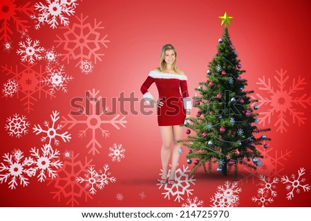 Pretty girl smiling in santa outfit against red snow flake pattern design