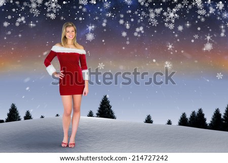 Pretty girl smiling in santa outfit against snow falling on fir tree forest