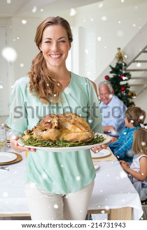 Happy mother with Christmas meal against snow falling