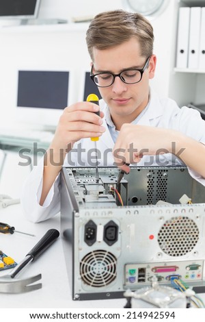 Computer engineer working on broken device with screwdriver in his office