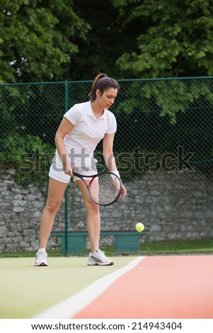 Pretty tennis player ready to serve on a sunny day