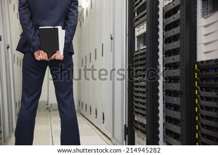 Technician standing in server hallway in large data center