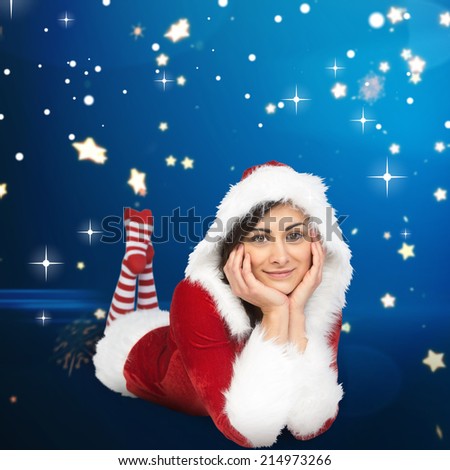 Pretty girl smiling in santa outfit against bright star pattern on blue